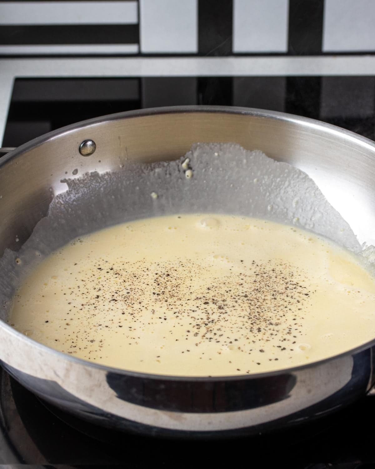 Pasta water and black pepper added to the lemon cream sauce