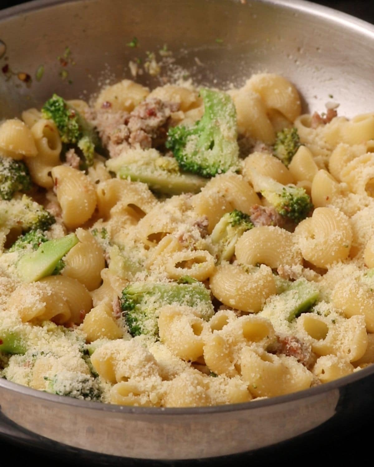 Parmesan cheese sprinkled over the top of the pasta in the skillet.