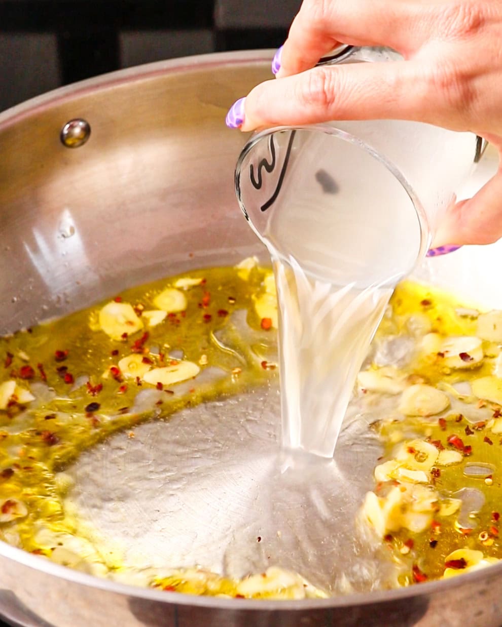 Pasta water being poured into the pan.