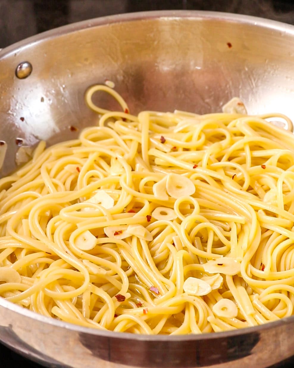 Cooked spaghetti mixed through the sauce in the pan.