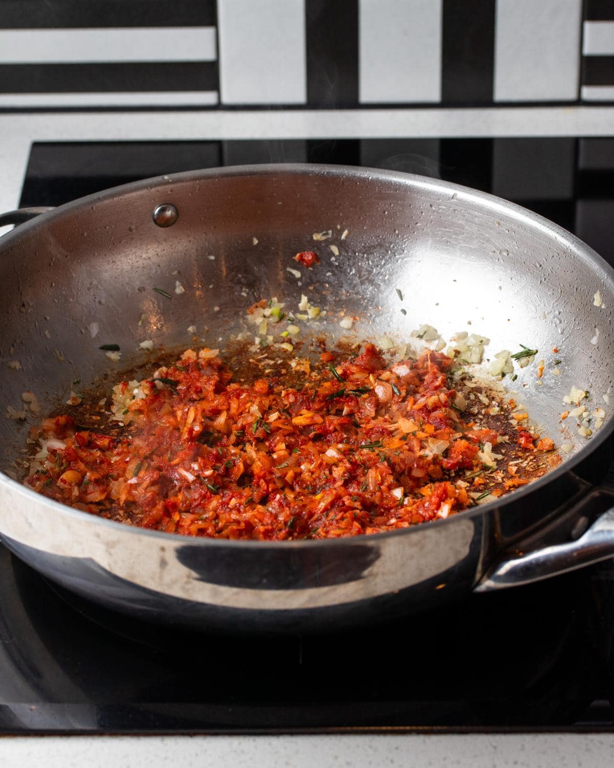 Tomato paste mixed into the onion mixture in the pan.