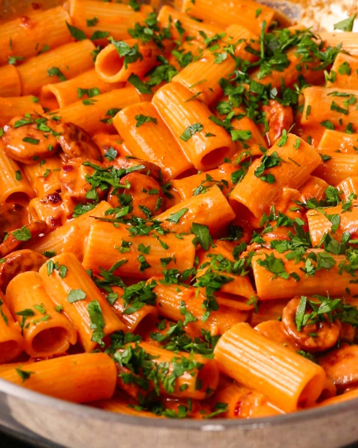Chopped parsley sprinkled on top of the finished pasta dish in the pan.