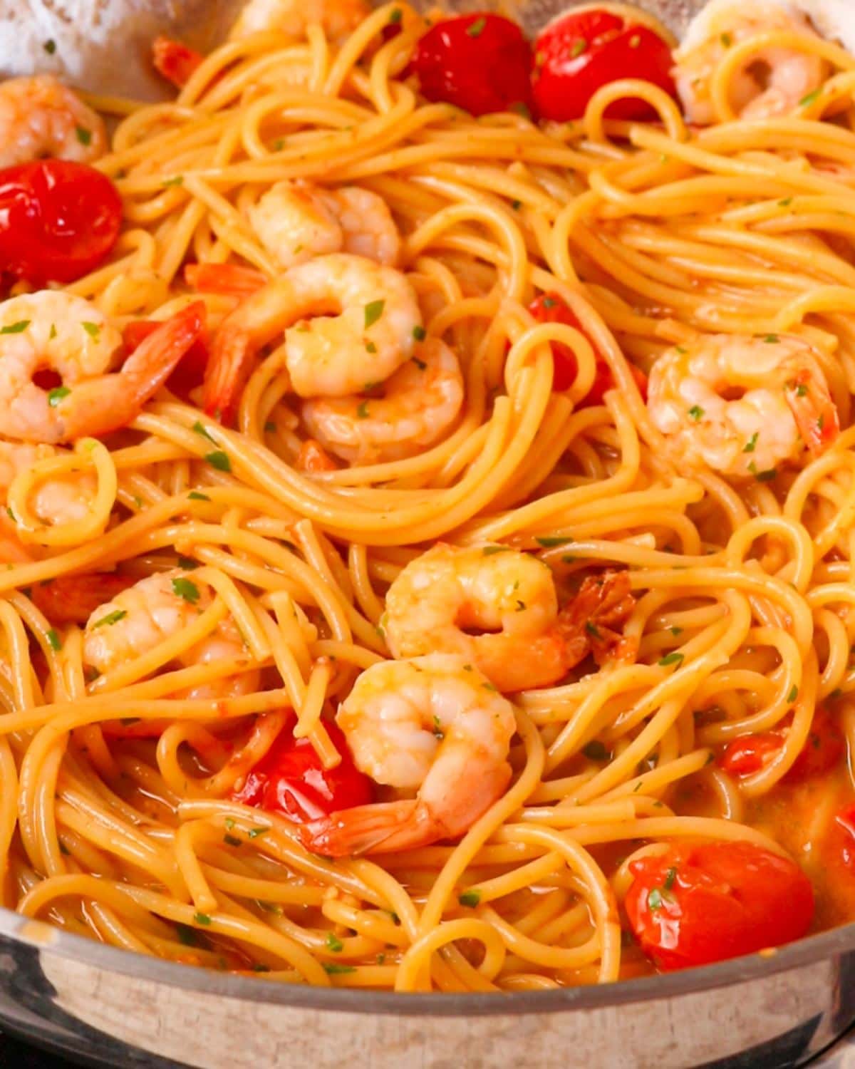 Cooked shrimp added onto the top of the pasta in the pan. Chopped parsley sprinkled through.