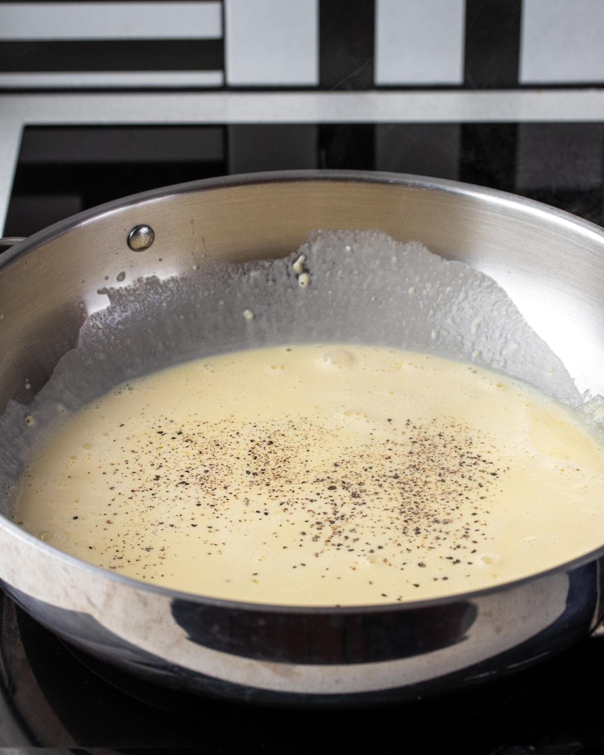 Black pepper sprinkled over top of cream sauce.