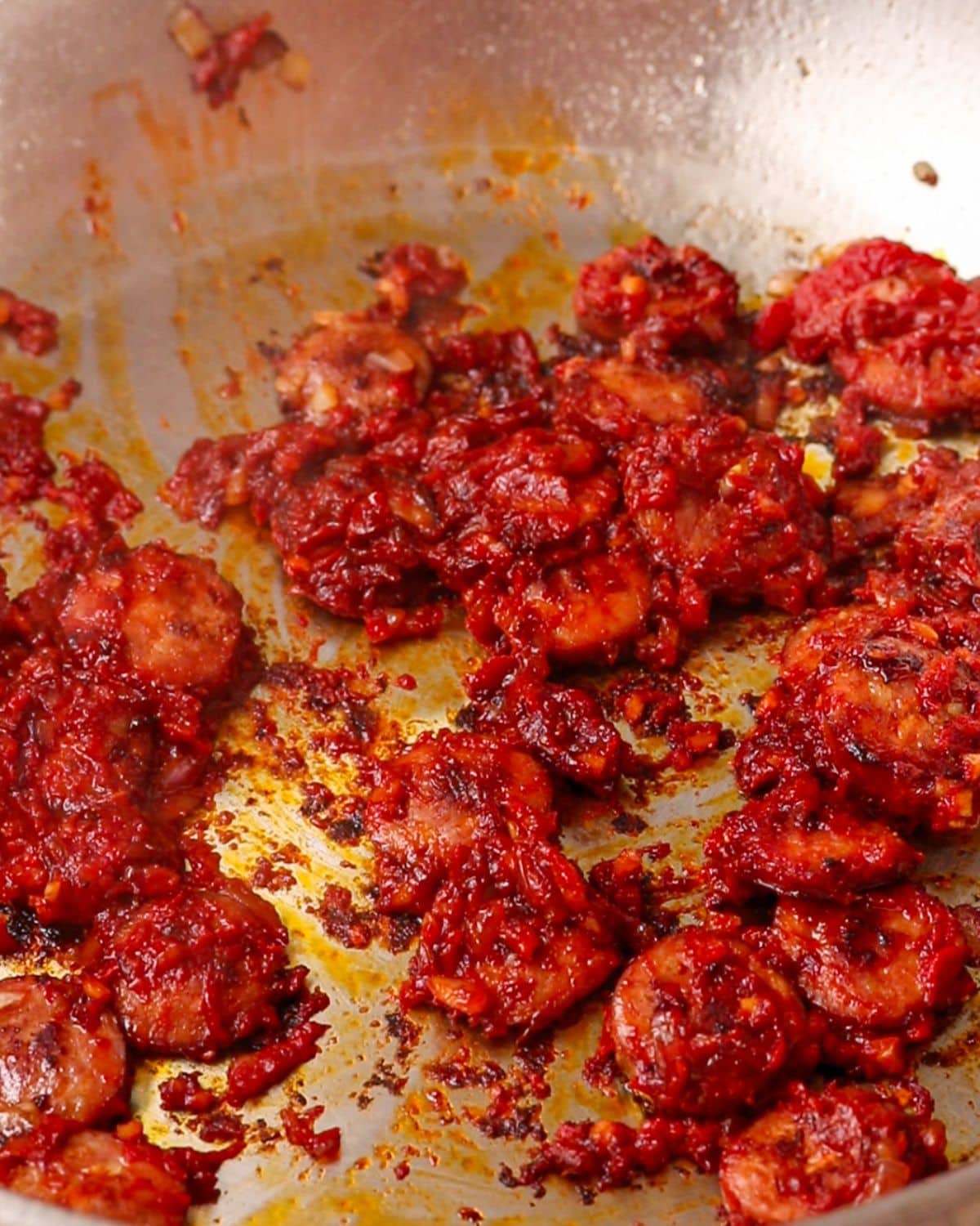 Tomato paste mixed into the chorizo in pan.