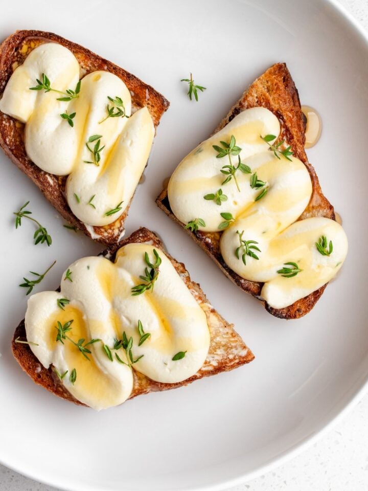 Golden toasted sourdough with piped whipped ricotta on top. Drizzled with honey and thyme leaves.