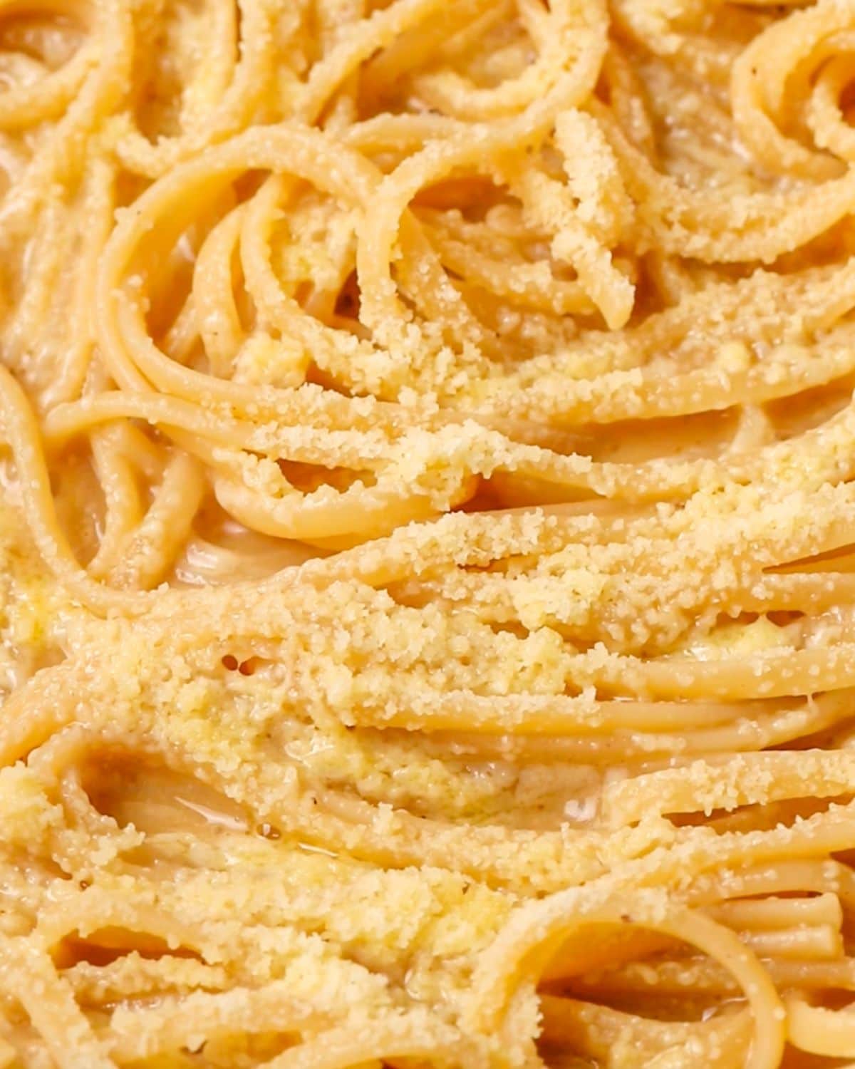 Grated parmesan melting on top of the pasta in the pan.