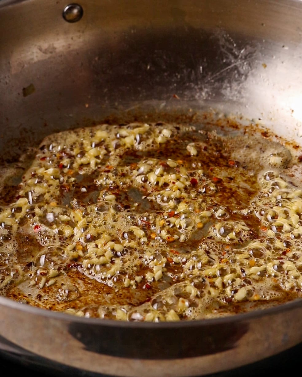 Garlic cooking gently in butter in a pan.
