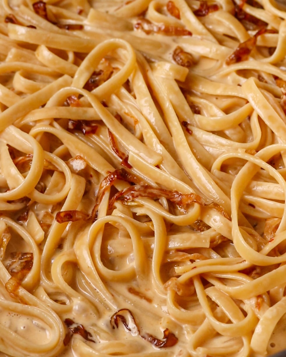 Caramelized onions stirred through creamy pasta until glossy and coated.