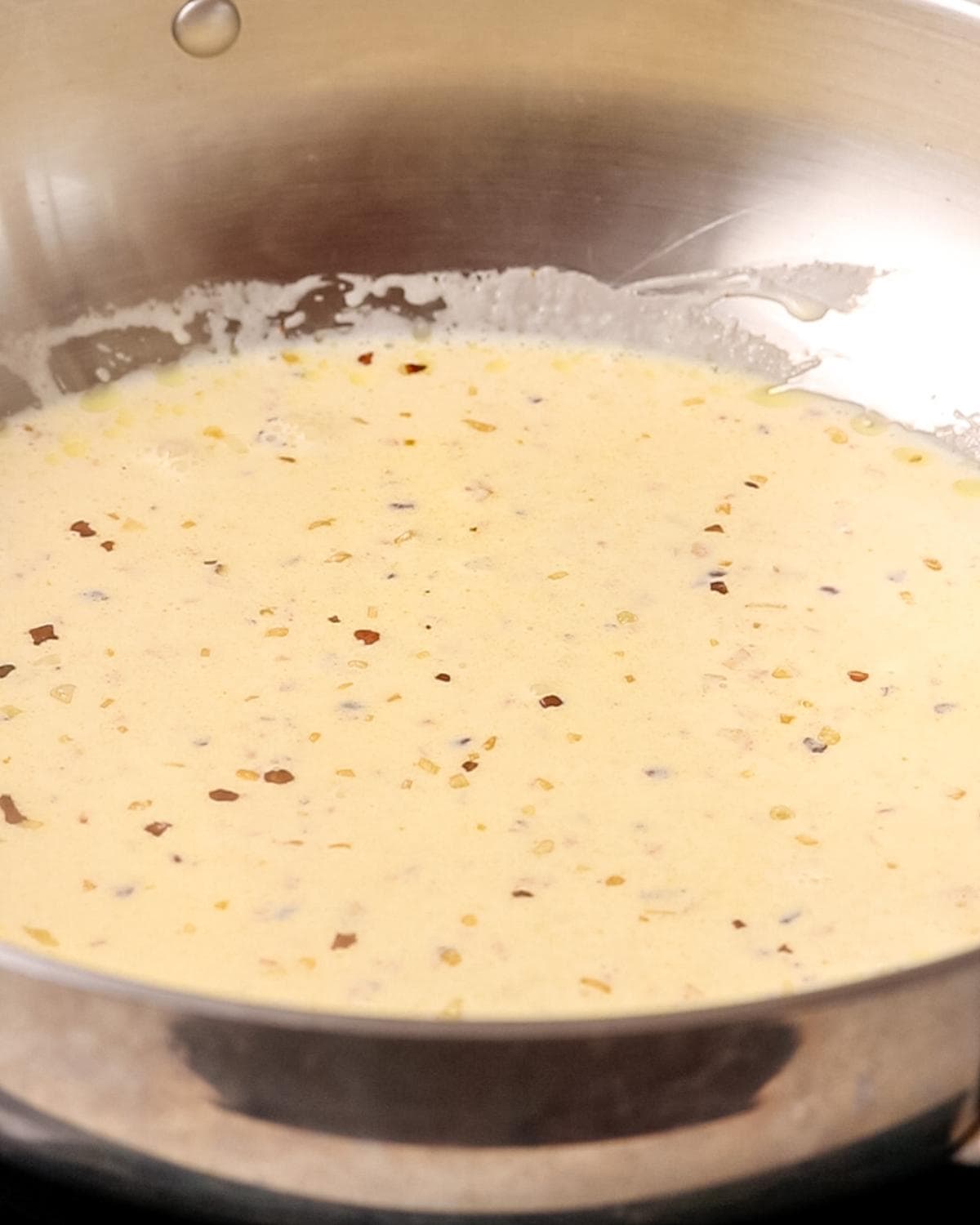 Cream added to garlic and butter mixture to make a creamy pasta sauce.