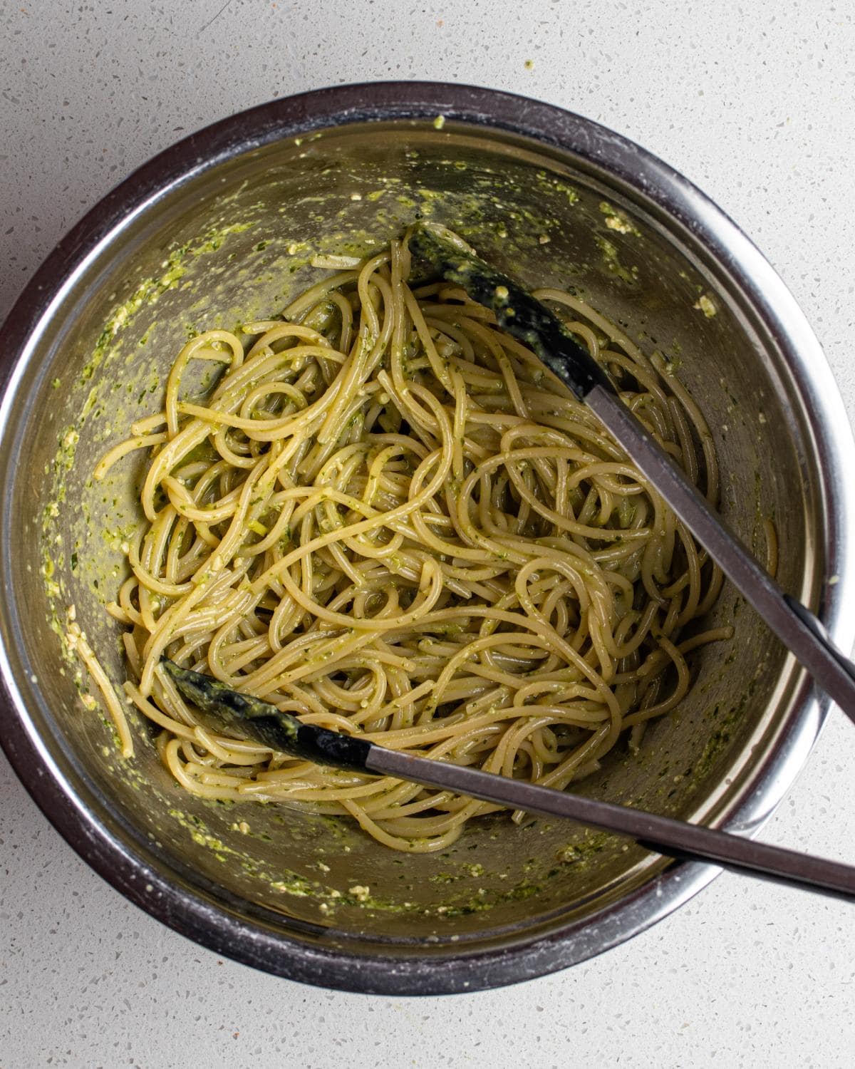 Pasta tossed with pesto until glossy and evenly coated