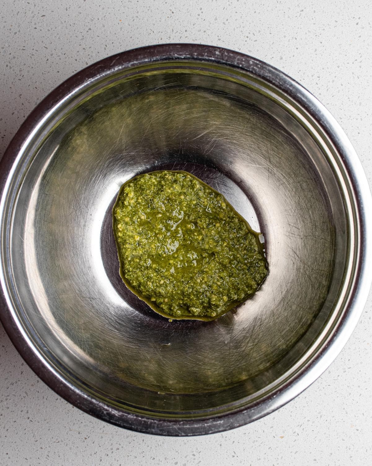 Pesto added to a large mixing bowl ready to make pesto pasta.
