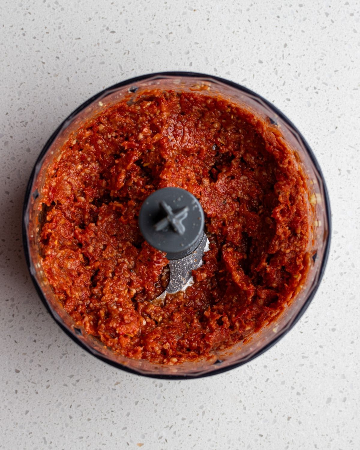 Sun-dried tomatoes and oil added to the food processor and blended into a thick paste.