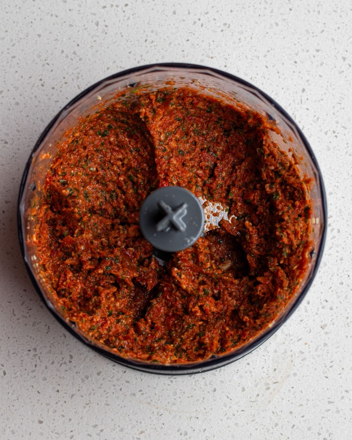 Adding fresh basil to the sun-dried tomato mixture.