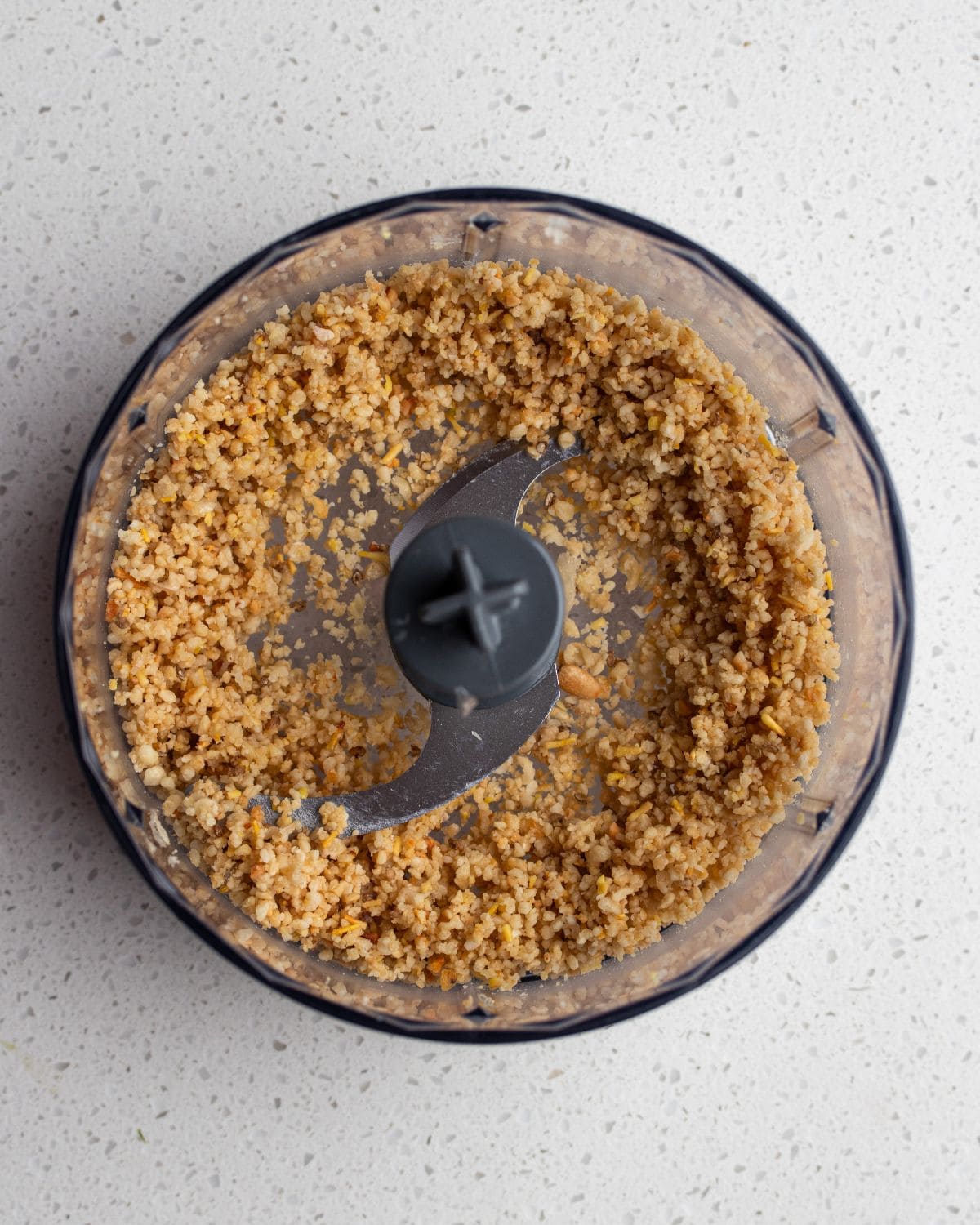 Blending pine nuts and garlic in a food processor until finely chopped.