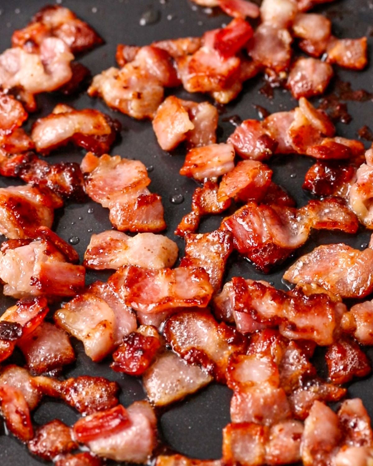 Bacon cooking in a skillet until golden and crisp.