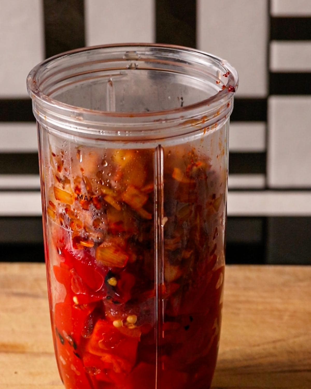 Cooked onion mixture and roasted red peppers in a blender before blending.