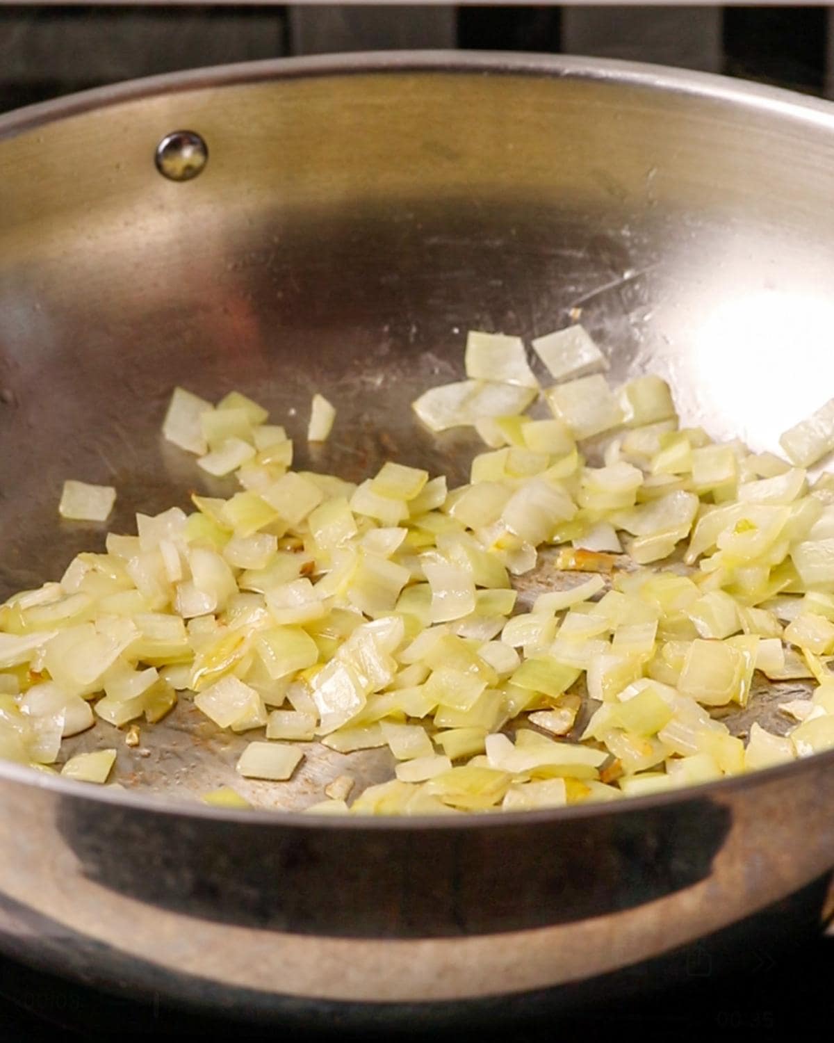 Diced onion cooking in olive oil until softened in a skillet.