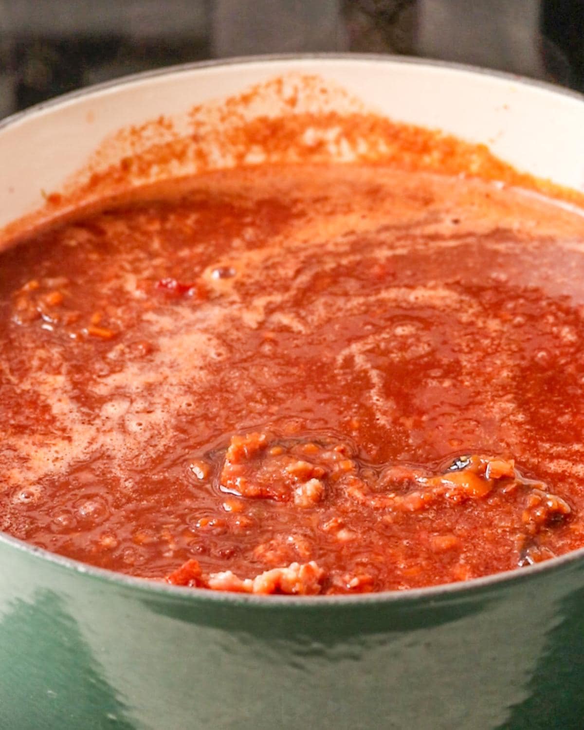 Beef chuck braising in red wine, tomatoes and herbs for slow cooked beef ragu.