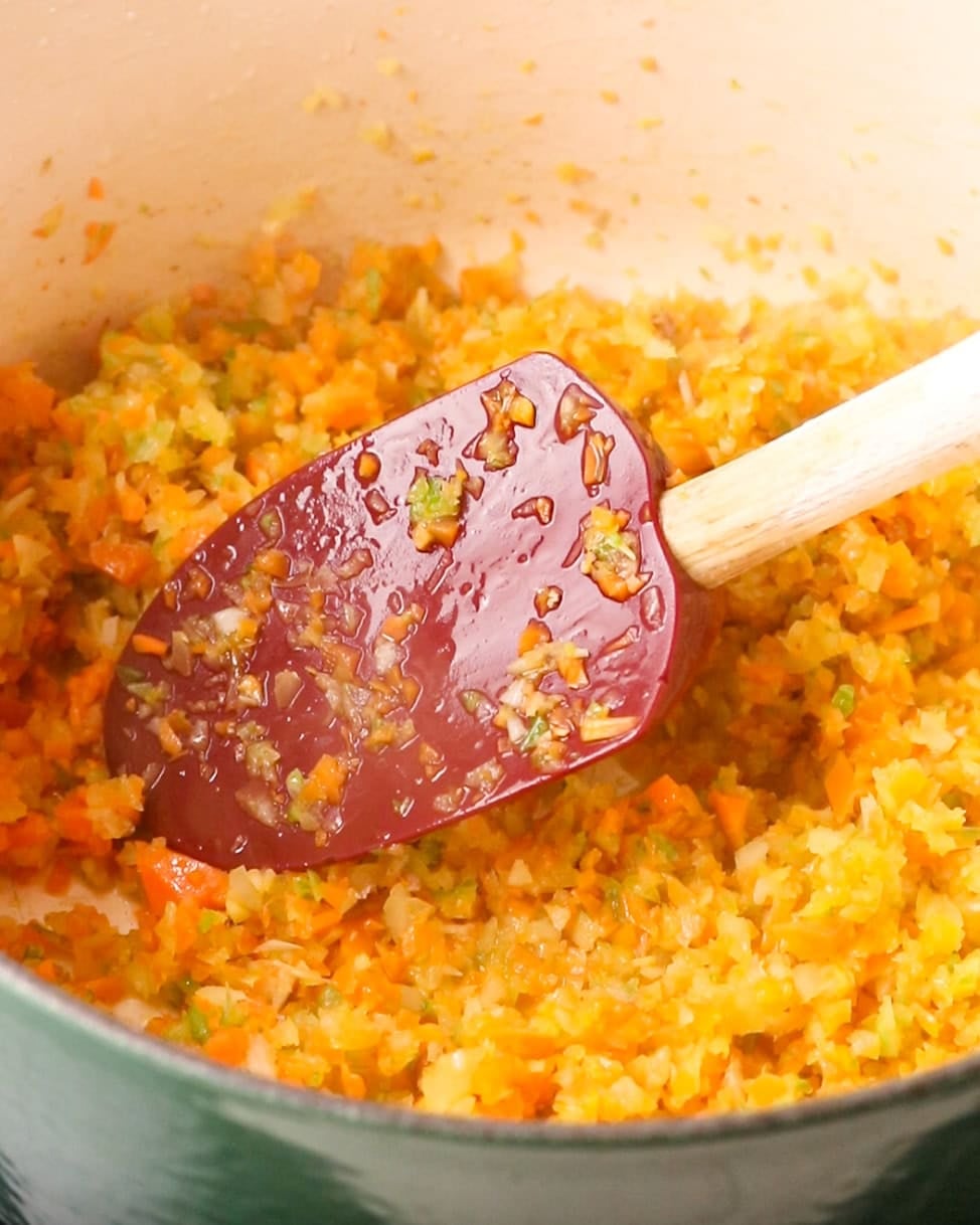 Finely chopped onion, carrot and celery cooking into a soffritto.