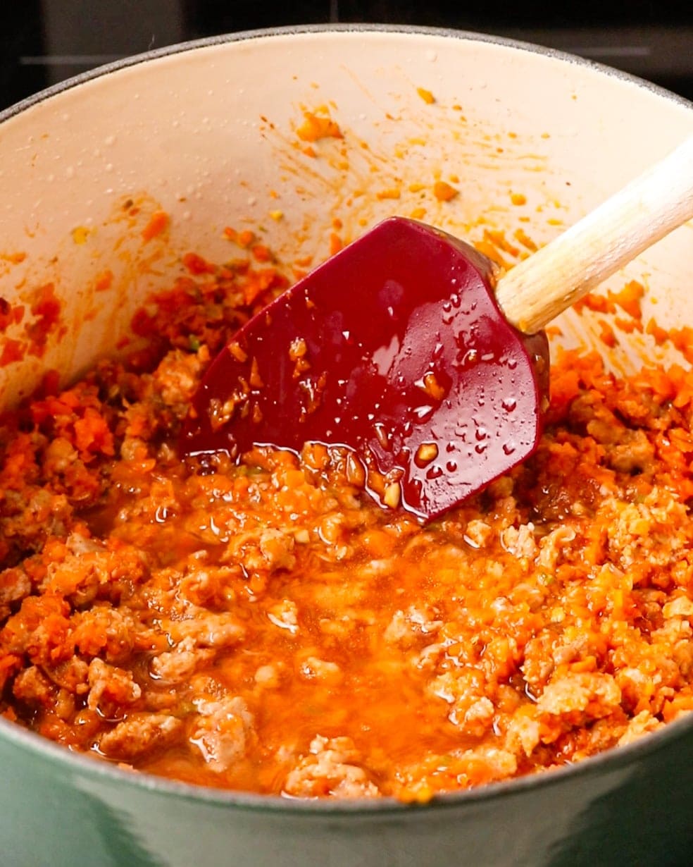 White wine being added to the pot to deglaze the sauce.