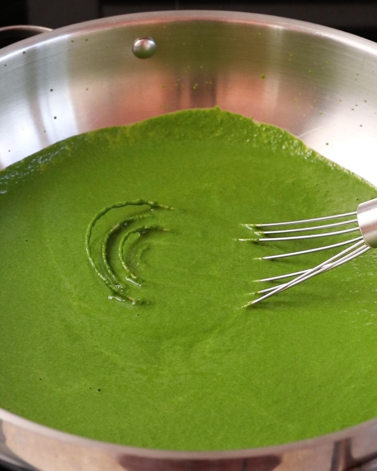 Vibrant green cavolo nero pasta sauce warming gently in a frying pan.