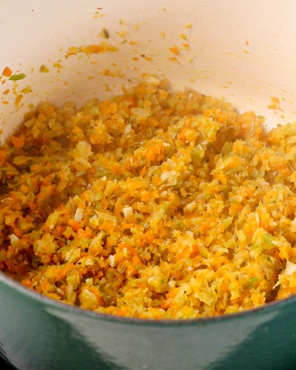 Finely chopped onion, carrot, celery and fennel seeds cooking for the soffritto.